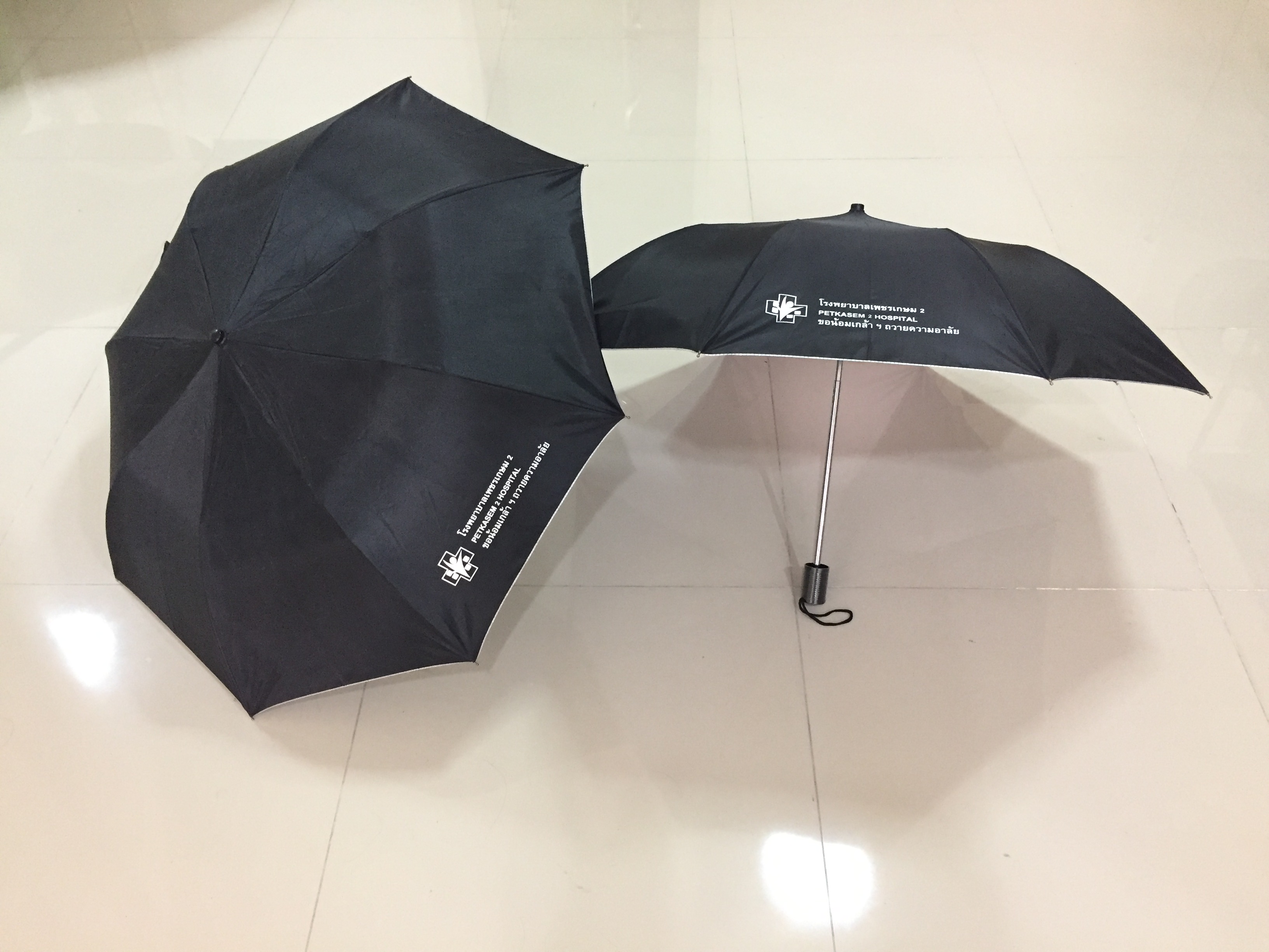 ร่มพับ2ตอน สีดำ ผ้ายูวี โครงเหล็ก มือเปิด ด้ามจับร้อยเชือก ปลอกผ้า สกรีนโลโก้